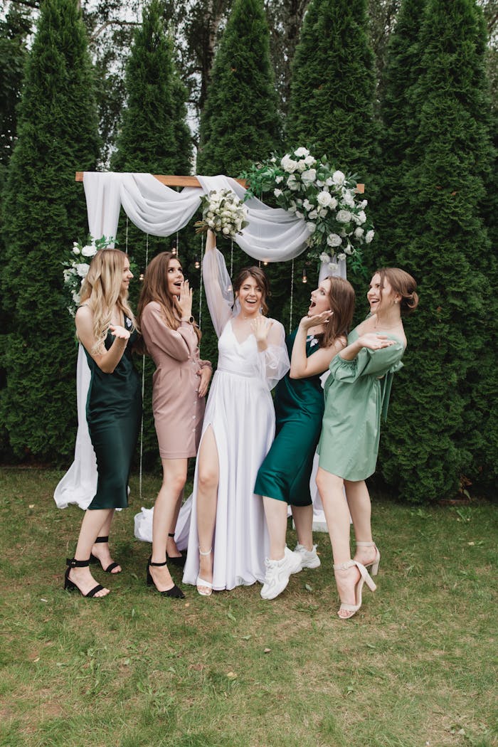 Mastering the First Impression: Your intriguing post title goes here A bride celebrates with her friends under an elegant floral arch outdoors.