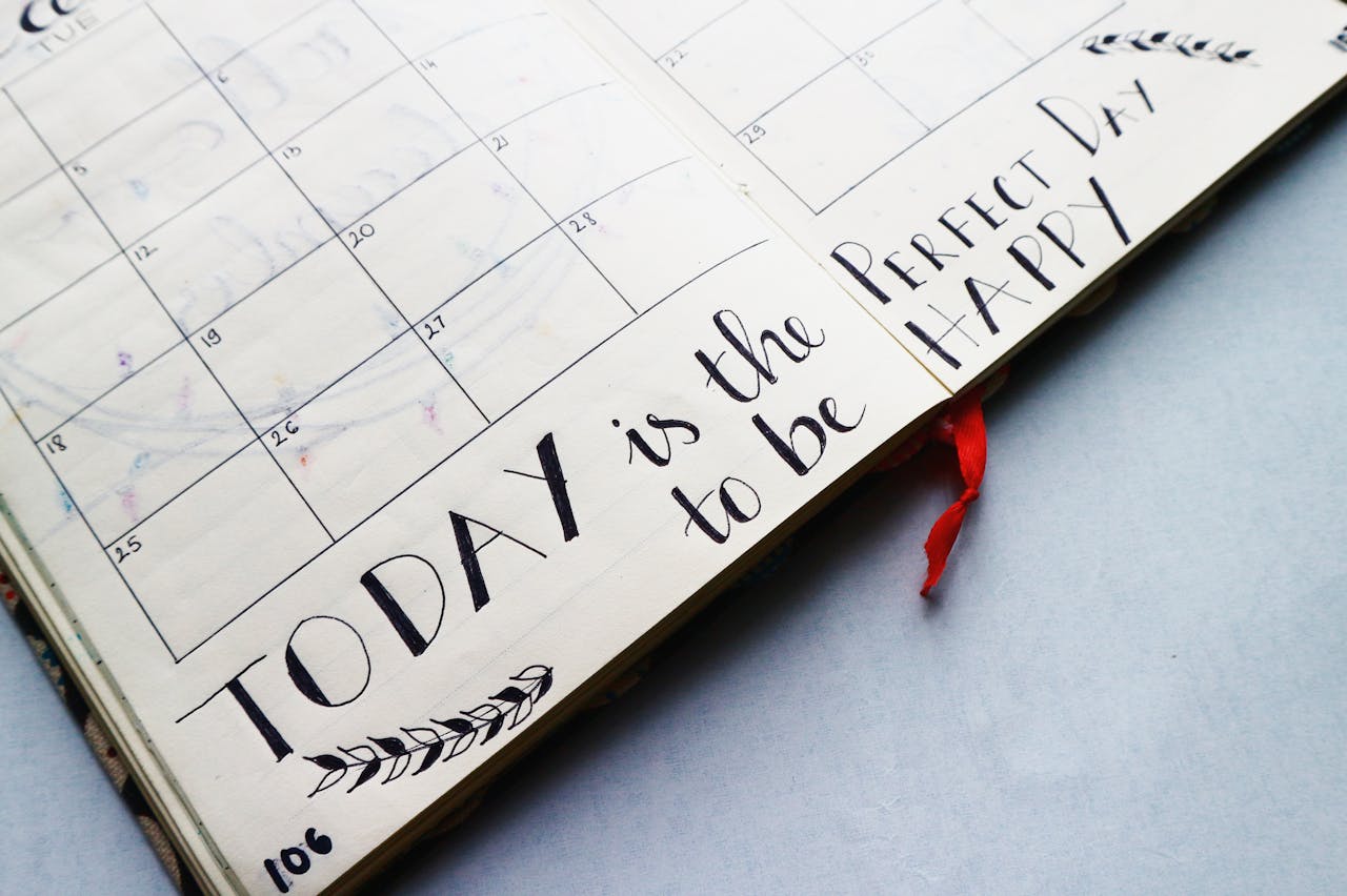 Crafting Captivating Headlines: Your awesome post title goes here Open planner with handwritten quotes and calendar layout, promoting positivity and organization.